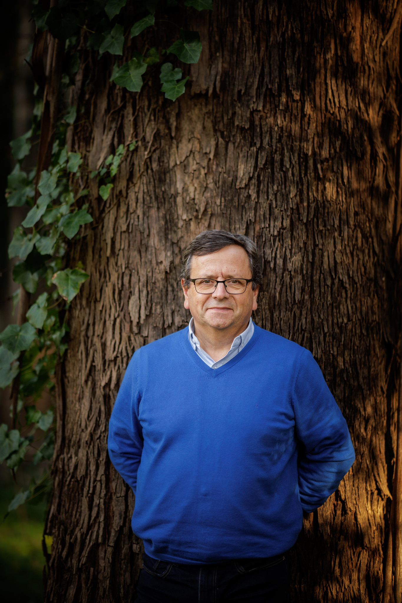 Carlos Pascoal Neto, investigador e especialista em bioeconomia, fotografado junto a uma árvore, em ambiente natural.